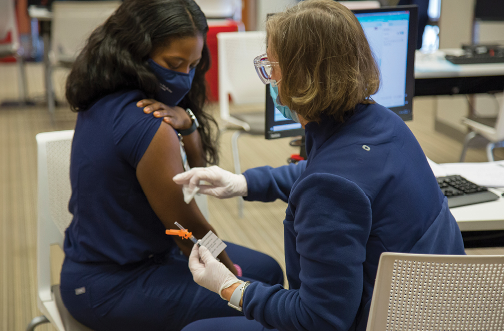 Tisha Payne, BSN, RN, a nurse in the Emergency Department at Princeton Medical Center receives a COVID-19 vaccination.